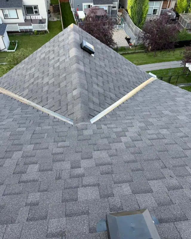 After: finished architectural shingle hip roof with ridge cap and vent