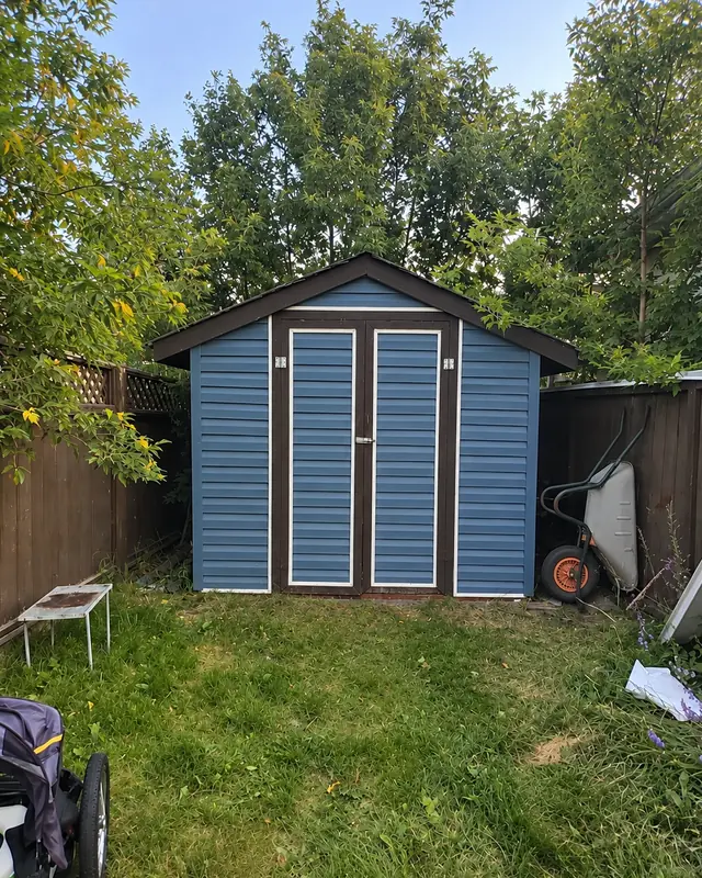 After: backyard shed with new blue siding, trim and doors