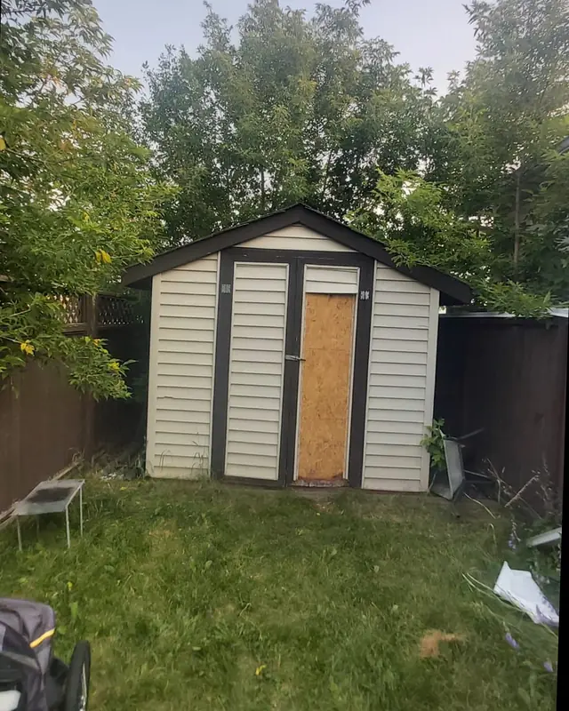 Before: weathered shed with a plywood door