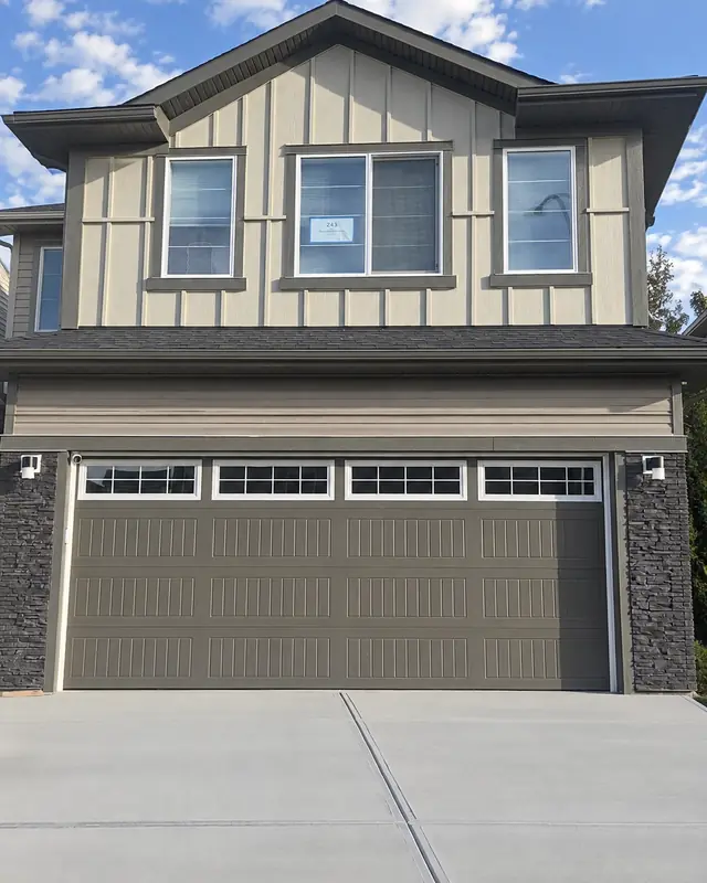 After: finished board and batten siding, trim and new garage door