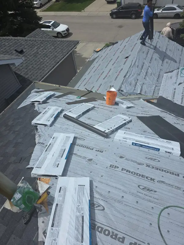 Roofing crew tearing off old shingles