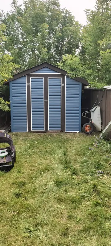 Backyard shed with new blue siding and doors