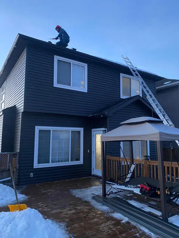 Crew installing siding and roofing in winter